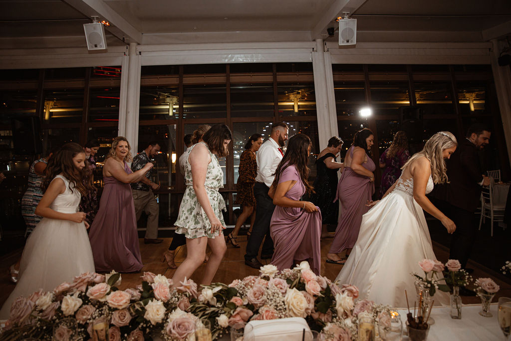 Group of wedding guests dancing on the dancefloor in lines