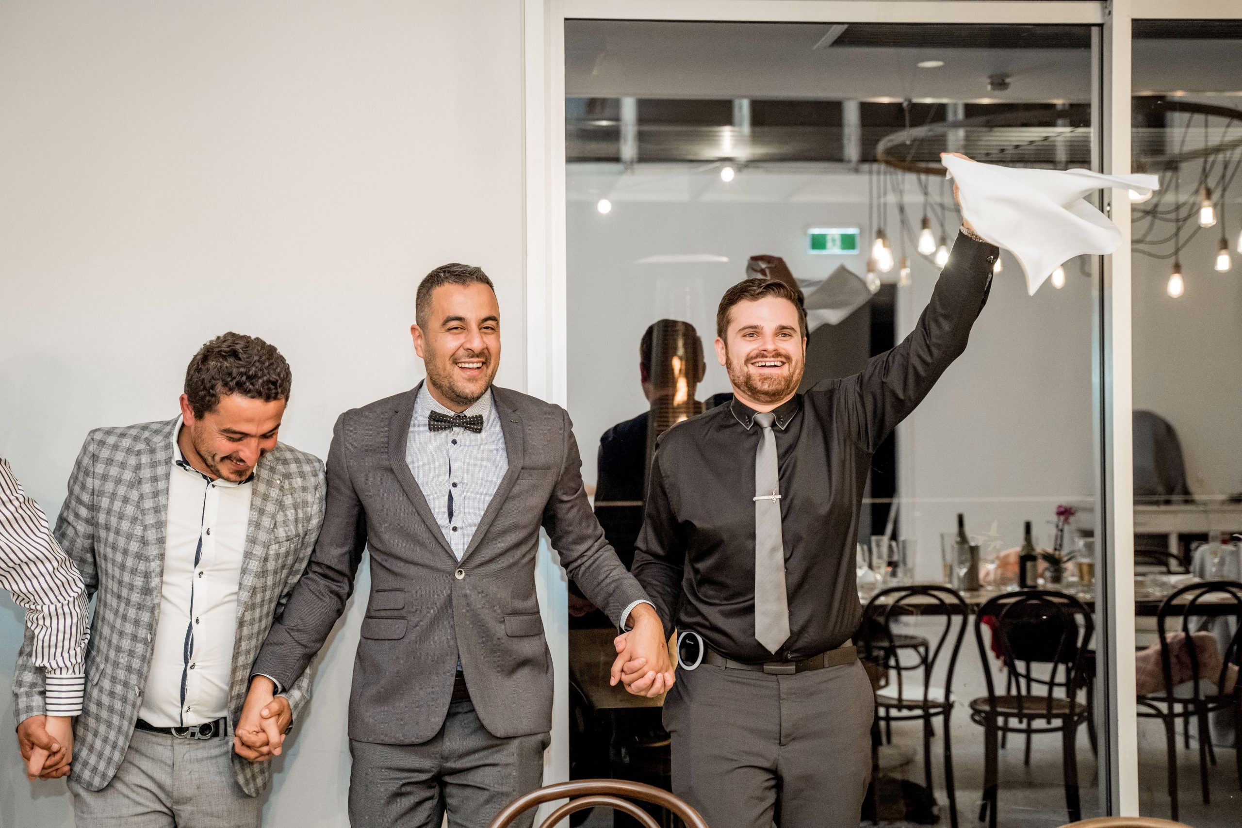 Nathan Cassar dancing with guests holding a napkin in the air